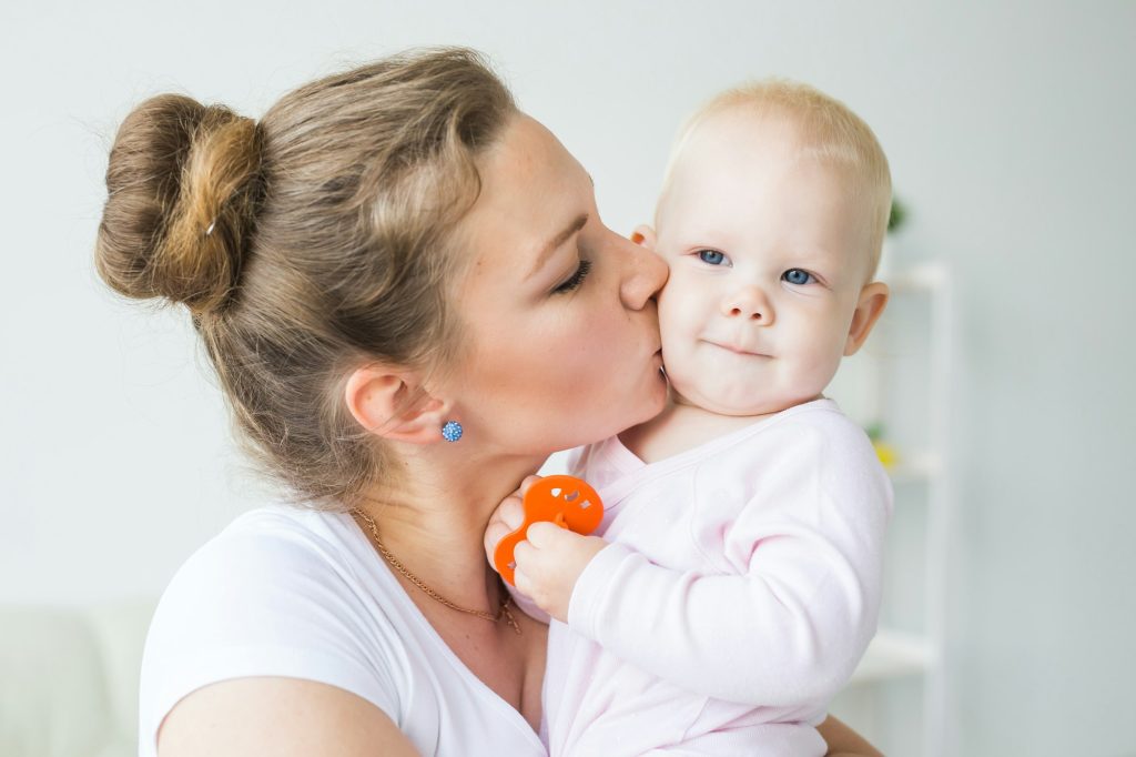 Mother hugs little baby. Happy woman with her daughter close-up
